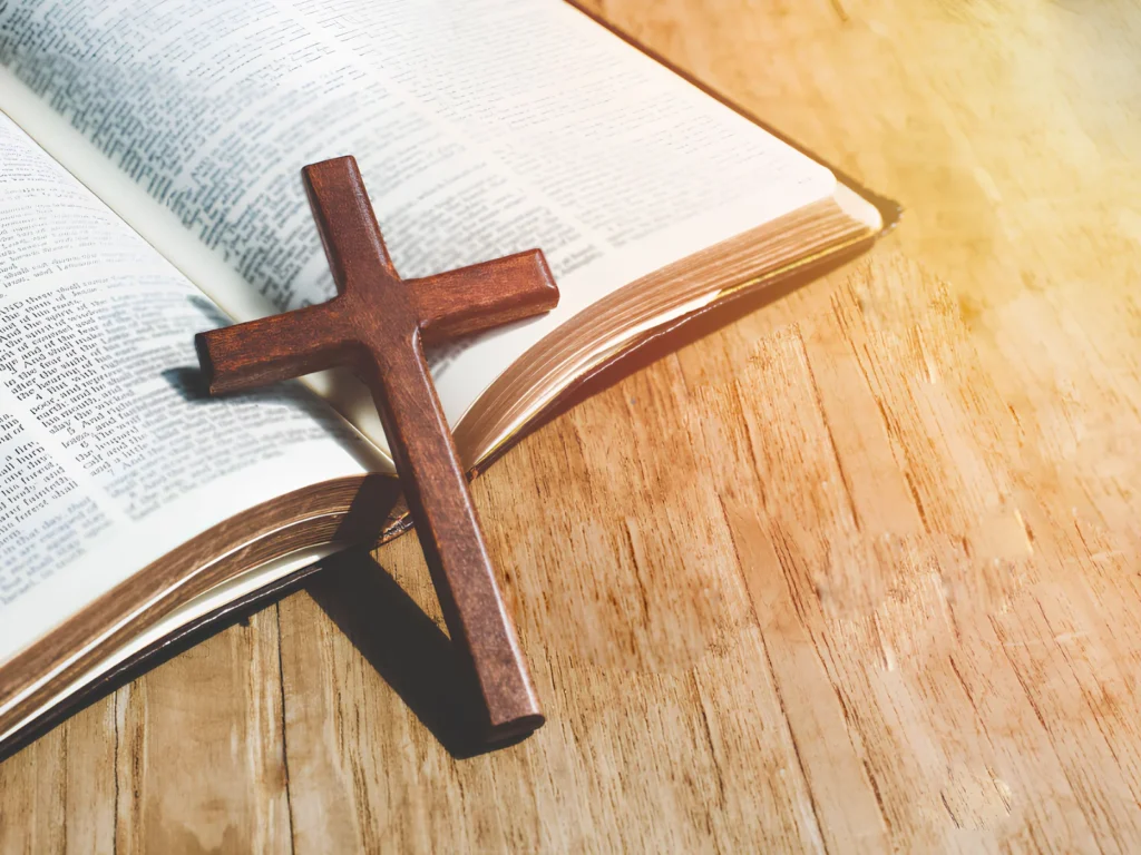 An image showing a Bible with highlighted passages and a cross.