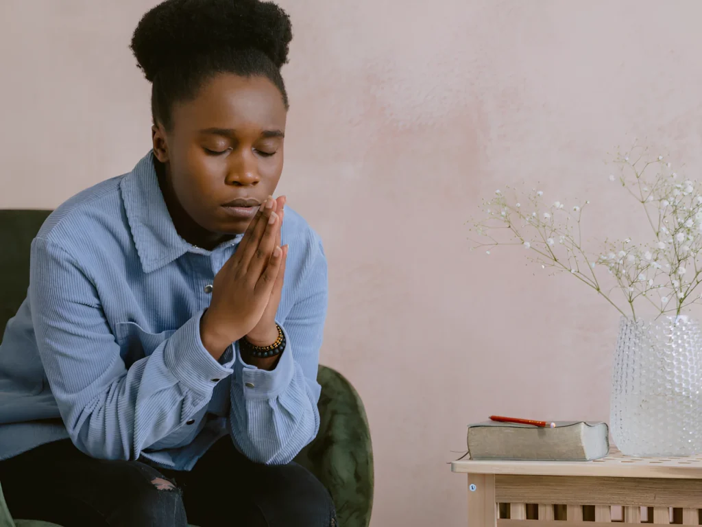 An image showing a person praying in a quiet, dedicated space.