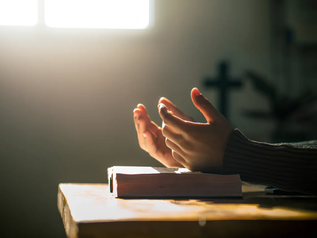 An image showing a person praying in the morning light.