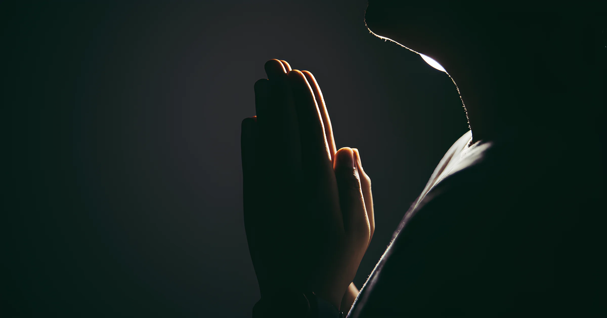 An image showing a person praying with a serene background.
