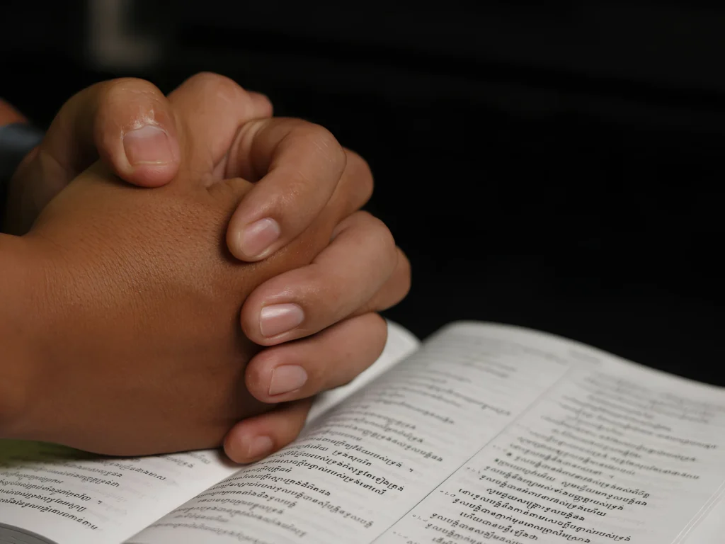 An image showing a person praying with an open heart and another person having an honest conversation.