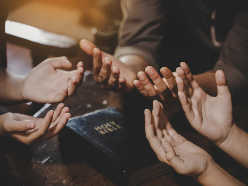 An image showing people praying together in a peaceful setting.